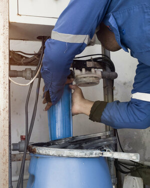 A man is installing a water treatment filter